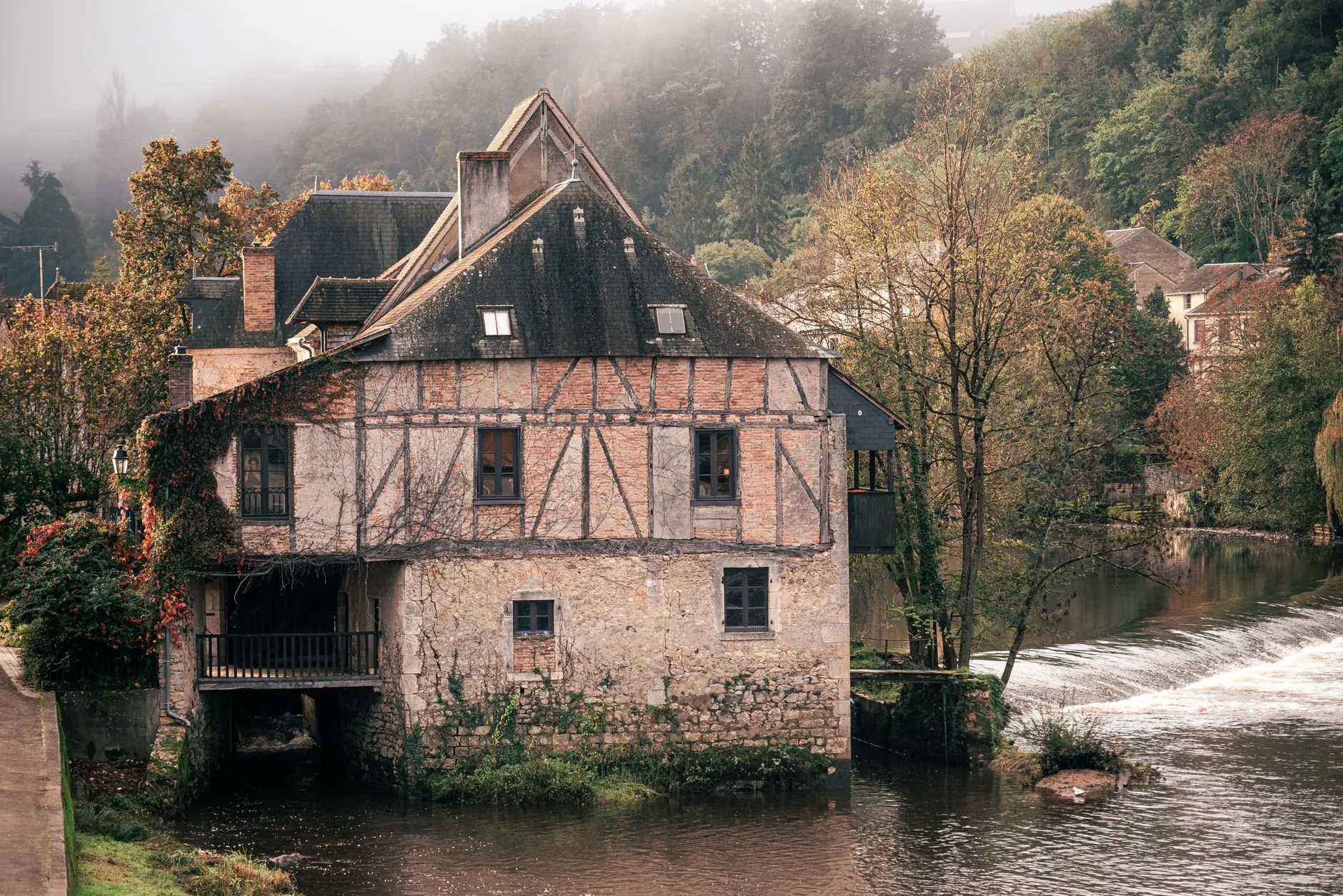 Maison au bord de l'eau en automne, évoquant les quais de l'Odet à Quimper
